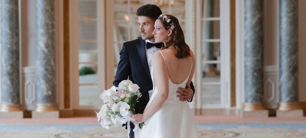 A bride and groom stand inside Fairmont Chateau Laurier