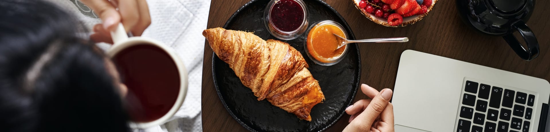 A person working and eating breakfast in bed at Fairmont Chateau Laurier