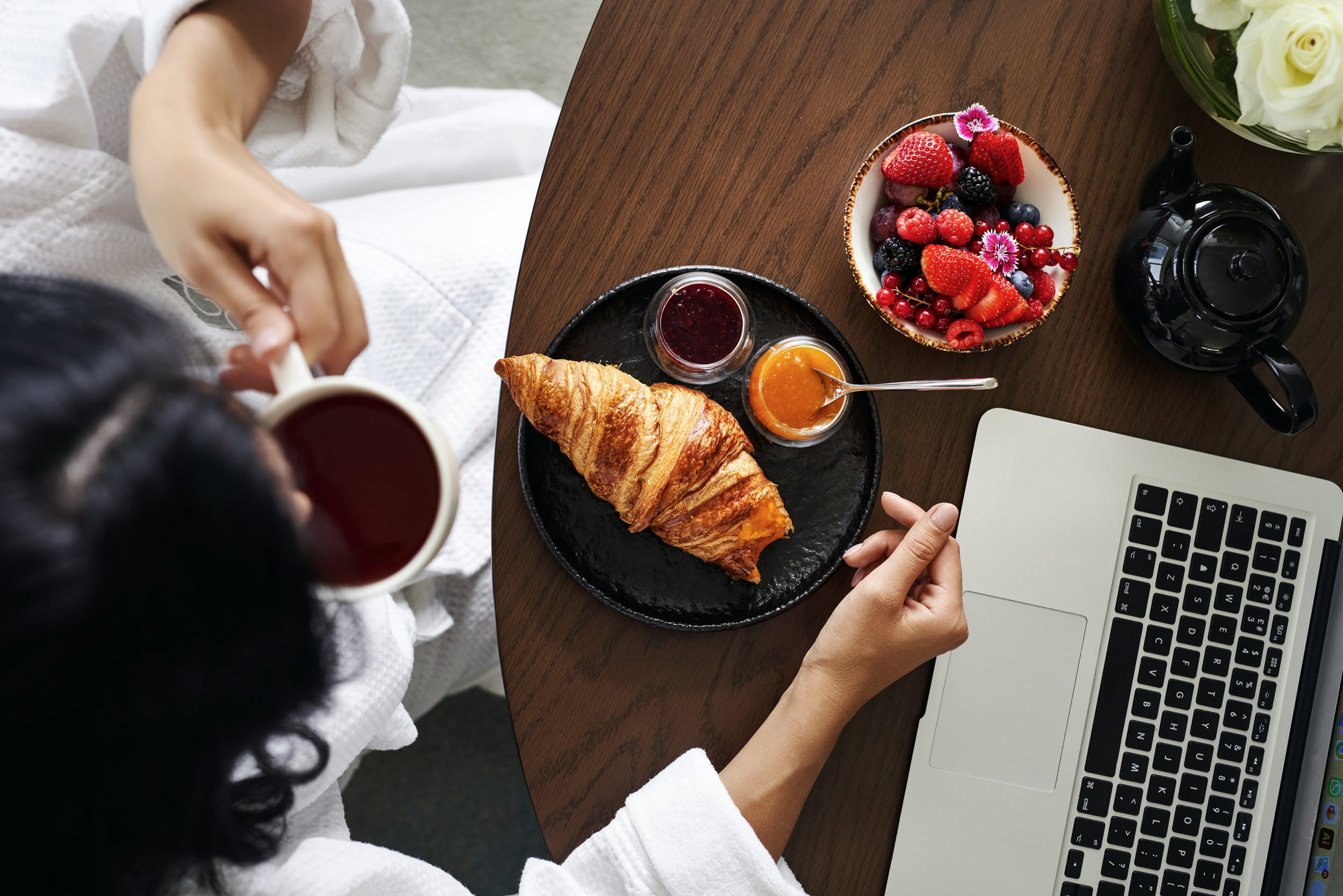 woman working while eating breakfast