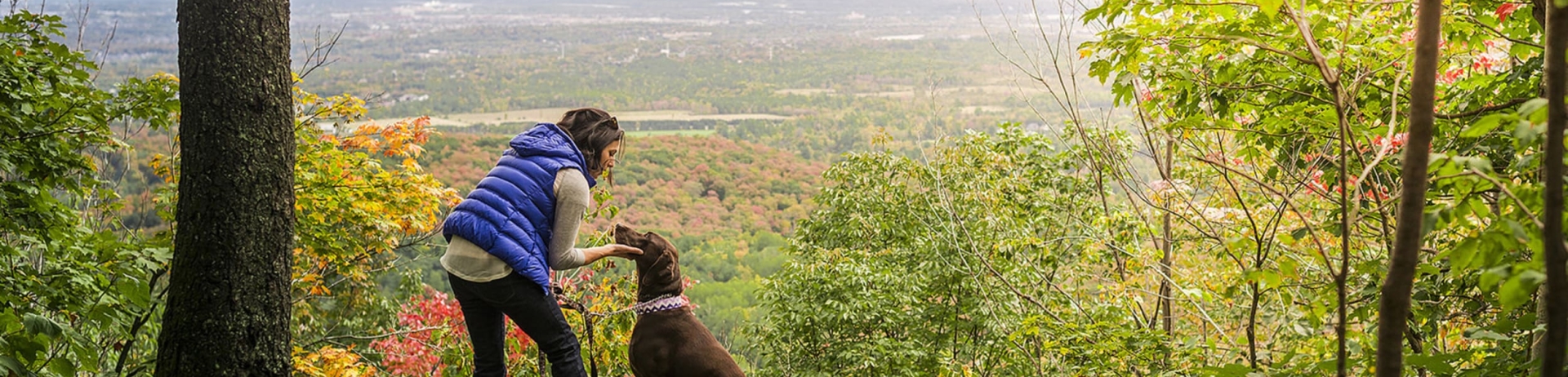 A woman and her dog hiking the hills of Ontario